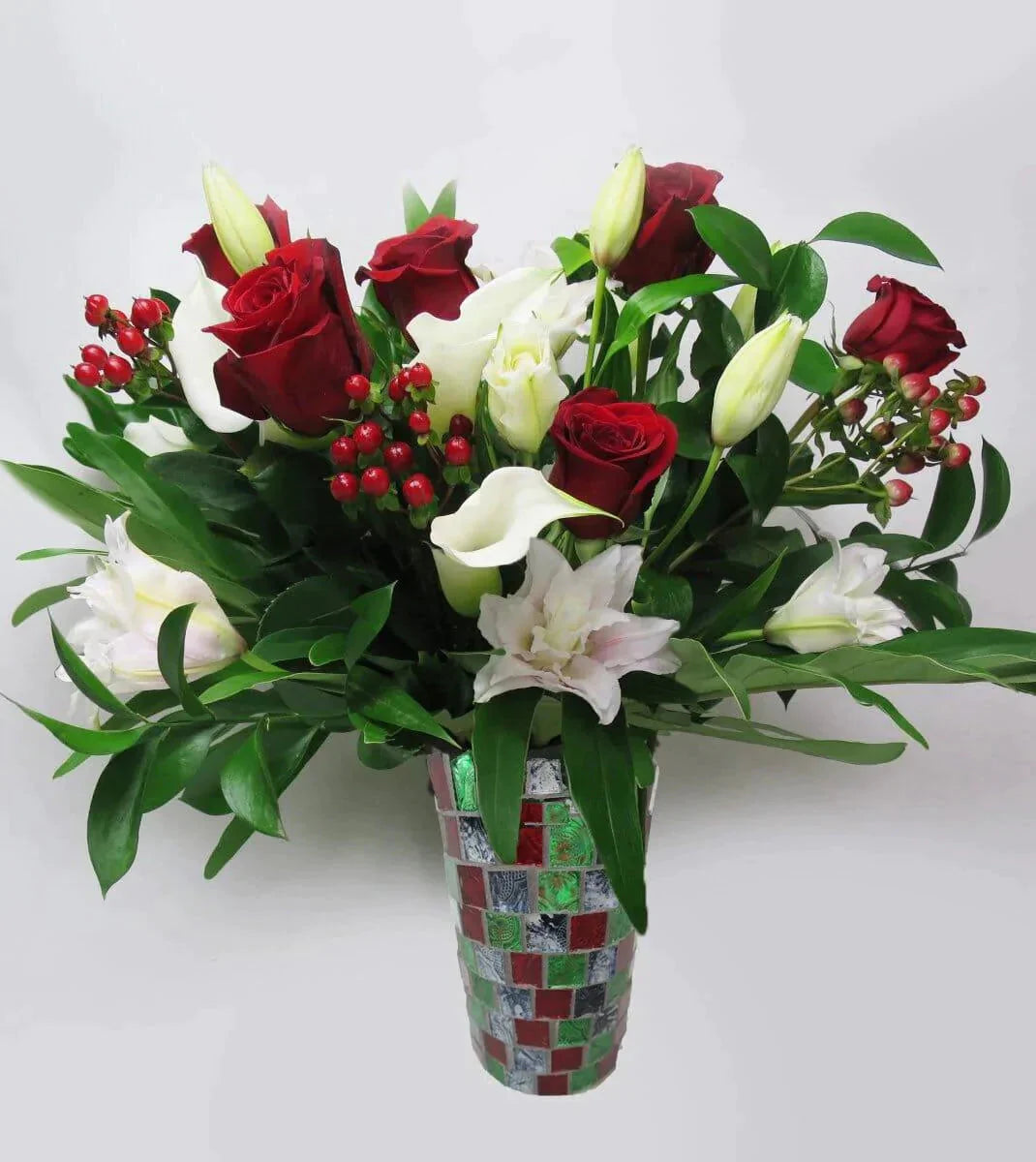 Christmas Marvel - vase of white rose lilies, red roses, callas, hypericum berries and assorted greens