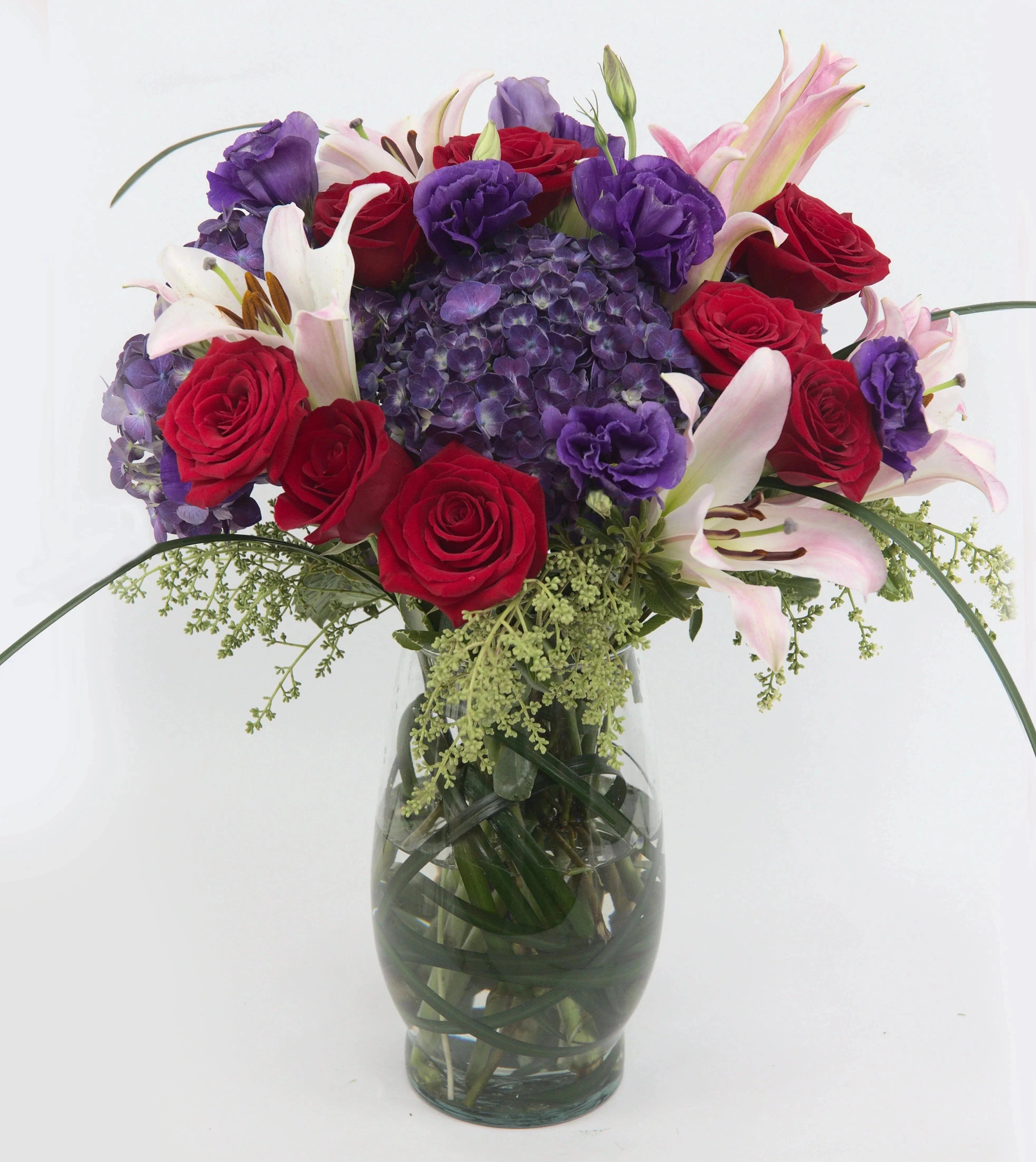 Love Shine Luxury Bouquet - vase of purple hydrangea, purple double lisianthus, red roses, pink roses, pink Asiatic Lilies, and lush greens