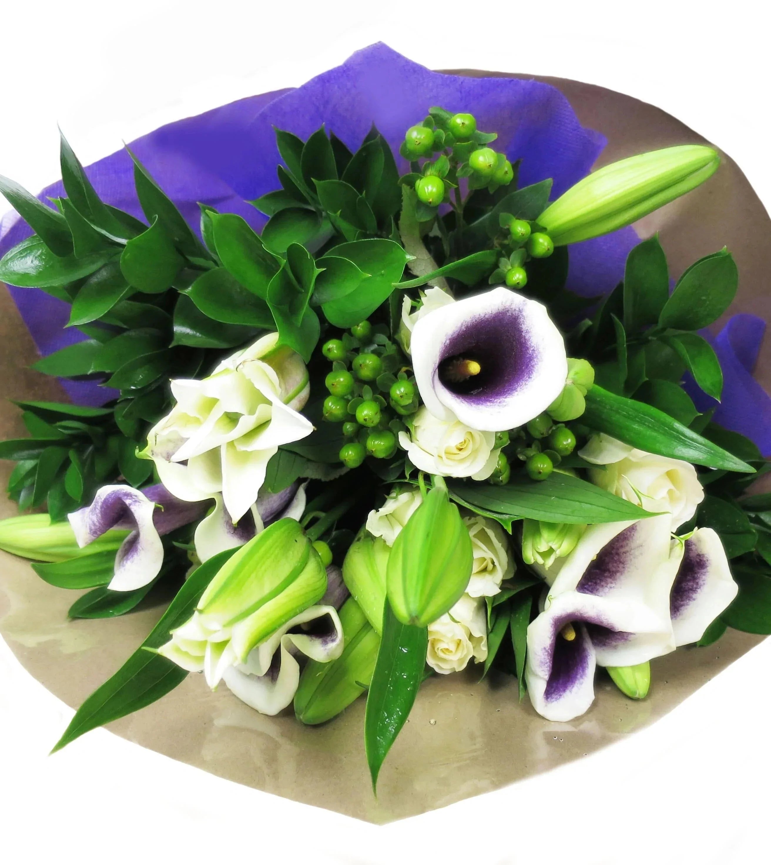 Picasso Bouquet - snow-white Lilies to create a grand statement in this joyful bouquet. White Roses, Green Hypericum berries, and Ruscus