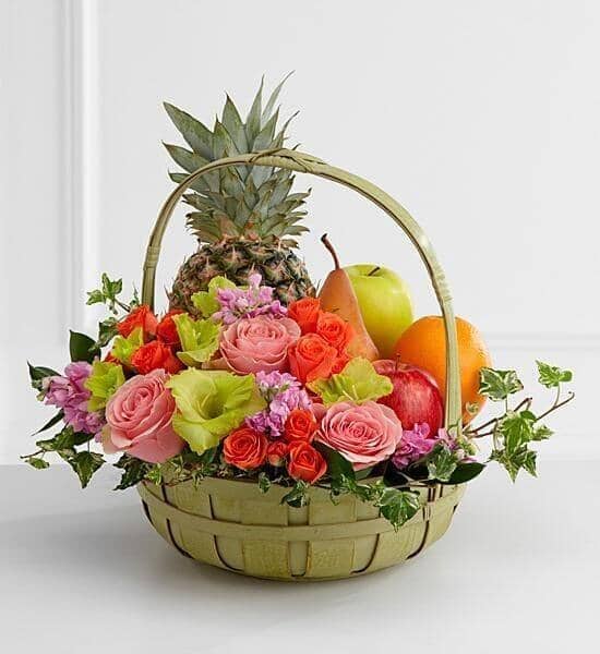 Rest in Peace - pink roses , pink stock , orange spray roses , green gladiolus , variegated ivy , greens , fruit , gift basket