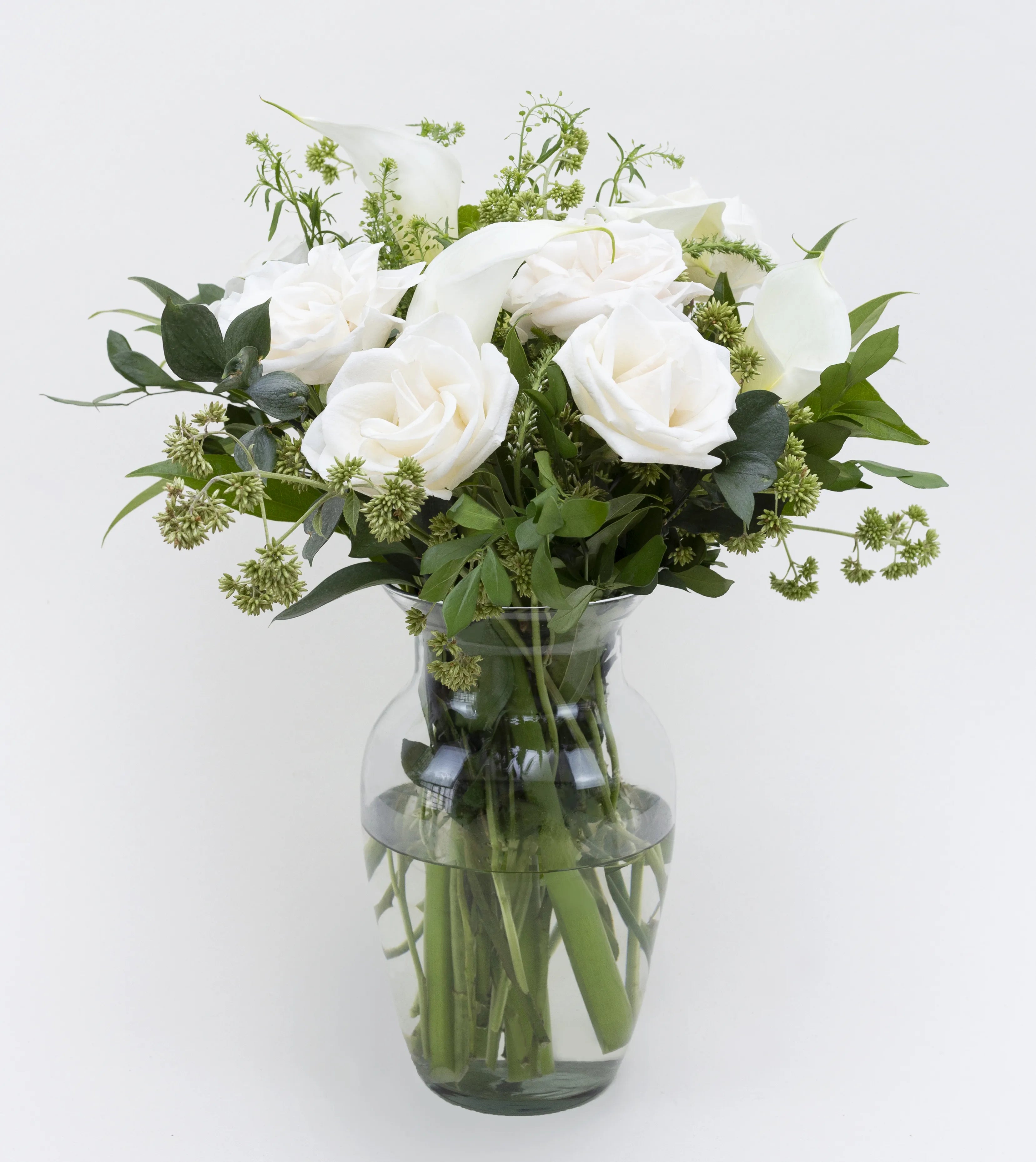 Arrangement of white roses and calla lilies that sends your sympathy in the most elegant way