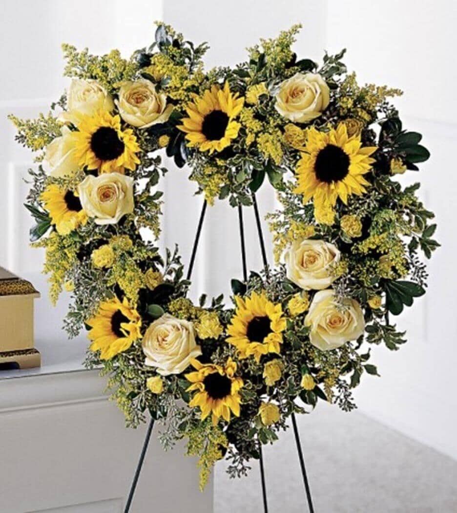 Forever Heart - Golden sunflowers, soft yellow roses, yellow carnations and solidago are enhanced with seeded eucalyptus to create this beautiful heart-shaped wreath