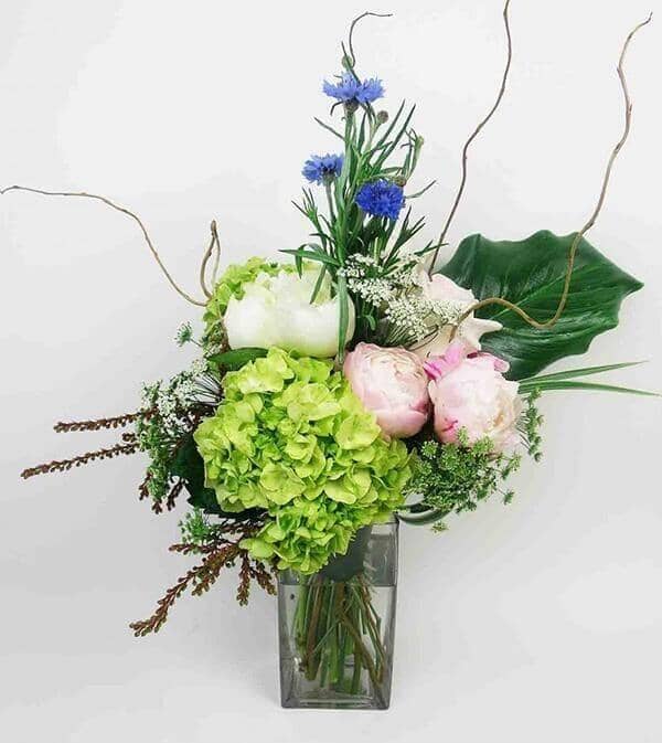 Garden Celebration™ -Peonies and hydrangeas are nicely accented with blue cornflowers, queen anne’s lace and lush greens