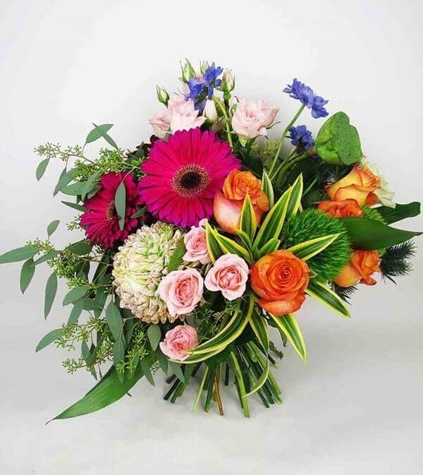 Wild One™ Bouquet - vase with roses, gerberas, commercial mums, thistles, scabiosa, lotus flower pods and dianthus that’s gorgeously decorated with seeded eucalyptus