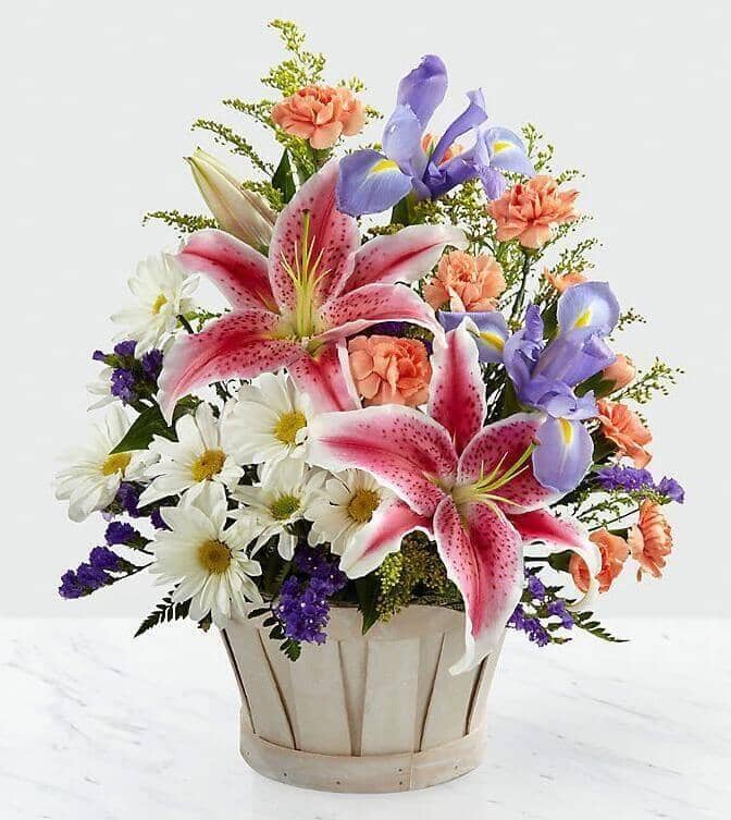 Wondrous Nature™ Bouquet - stargazer lilies , blue iris , white daisies , orange mini carnations , purple statice , yellow solidago , basket arrangement
